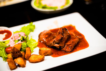 Beefsteak with BBQ sauce on with fried potatoes and salad