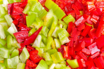 Surface coated with a sweet bell pepper cut into colorful pieces composition as an abstract food background