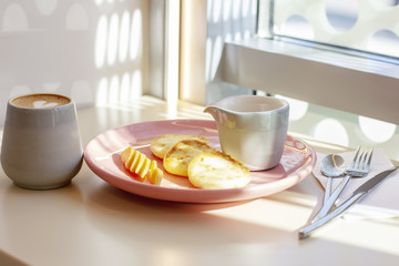 Breakfast in the cafe cheesecakes with fruit and coffee, hard light