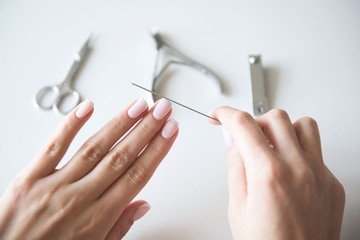 Woman making manicure with nail care tools background. French manicure. - obrazy, fototapety, plakaty