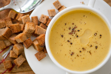 Top view, cream soup in a white plate and croutons of black bread. Вид сверху, крем суп в белой тарелке и гренки из черного хлеба.
