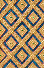Pattern of gold flower carved on stucco design of native wall, Thai style in temple