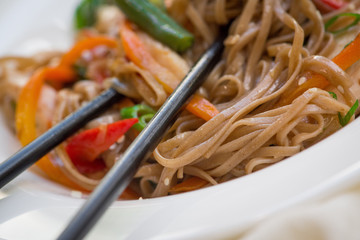 Wok with buckwheat noodles is close, a macro photo of the dish. Вок с гречневой лапшой близкая, макро фотография блюда.