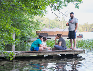 Happy family members eating watermelon on a dock