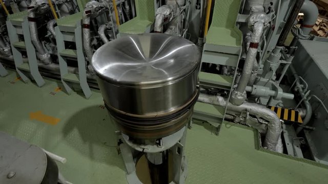 New piston near large diesel engine of ship
