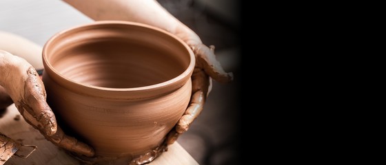 Hands of potter making clay pot, closeup