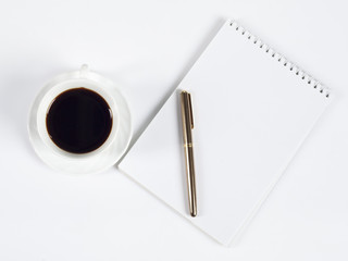 cup of coffee and pen on notebook
