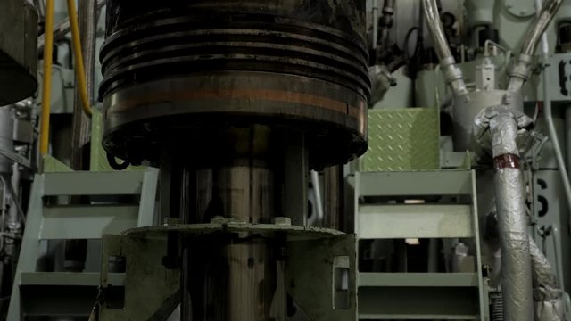 Used piston near diesel engine of ship