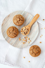 Teff hazelnut muffins on a plate with a scooper filled with hazelnuts.