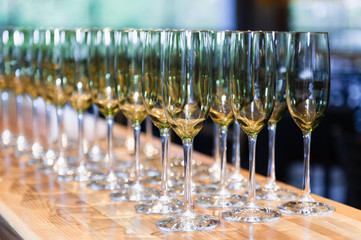 Empty white wine glasses ordered in symmetry on a countertop.