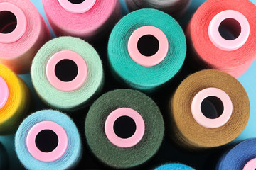 Background of multi-colored bobbins with thread, accessories for sewing. top view