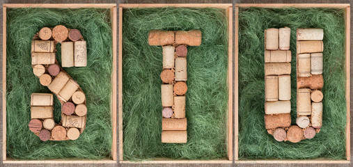Alphabet letter S T U  made of  wine corks on green background in wooden box. ABC set
