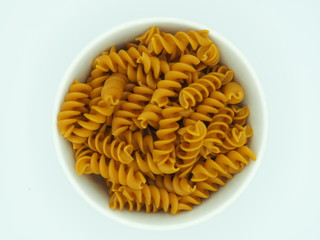 Pasta alimenticia en forma de espirales en bol de cerámica.