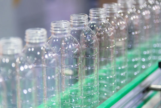 The New Plastic Bottles On The Conveyor Belt At The Drinking Water Factory. Drinking Water Manufacturing Process.