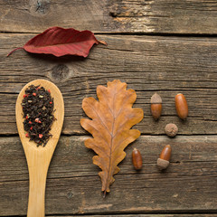 Naklejka na ściany i meble Cup of tea with autumn leaves on wooden background