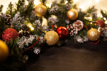 Christmas holiday background. Gifts with a red ribbon, Santa's cap and decor under a Christmas tree on a wooden board. 
