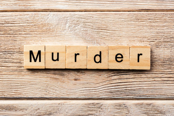 murder word written on wood block. murder text on table, concept