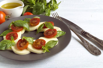 Caprese salad with ripe tomatoes and mozzarella with fresh Basil leaves. Italian food.