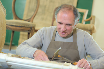 portrait of retired carpenter sitting at his workshop