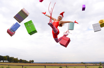 A young girl wearing a Santa Claus  hat shows her happy  feelings for Christmas with jumping up in...