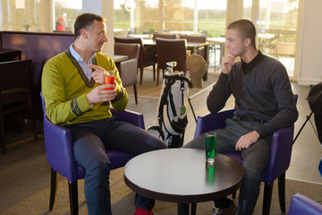 Two men sat in a bar having a drink