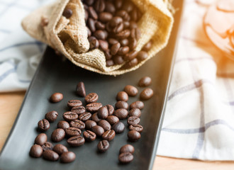 Coffee beans in the sackcloth on black plate