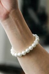 Handmade pearl bracelet on the forearm of a woman's hand