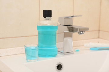 Mouthwash near tap on sink in bathroom. Teeth and oral care