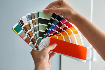 Female interior designer with color palette samples indoors, closeup