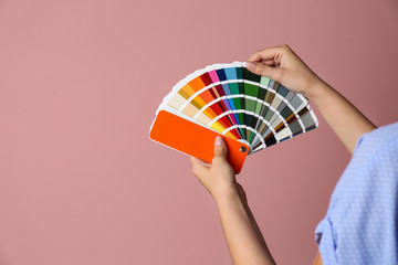 Female interior designer with palette samples on color background, closeup. Space for text