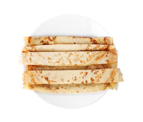 Tasty thin pancake rolls on plate against white background, top view
