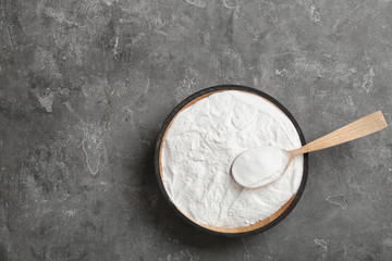 Bowl of baking soda with spoon and space for text on table, top view