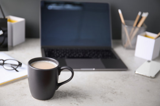 Black cup with coffee on office table. Space for text