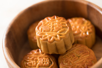 Traditional pastry mooncakes is offered to friends or family during Mid-Autumn Festival. Flatlay table top view dark light with copy space. The Chinese character represent 