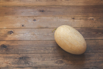 Huge yellow melon on a floor of a wooden terrace