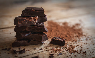 Close-up of stacked dark chocolate on wooden background 