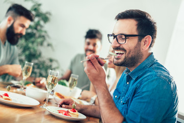 Group Of Happy Young Friends Enjoying Dinner At Home. Group of multiethnic friends enjoying dinner party