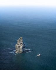 Cliffs of Moher - Irland - Felsen im Meer mit kleinem Boot im Vordergrund