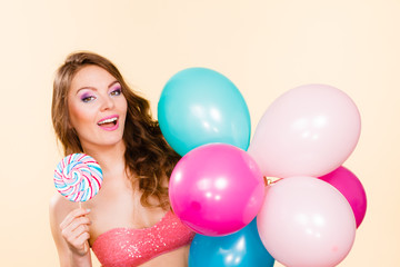 Fototapeta na wymiar Woman holds lollipop candy and balloons