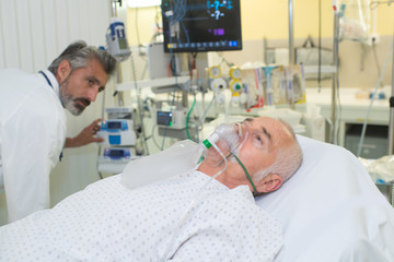 Man receiving oxygen in hospital bed