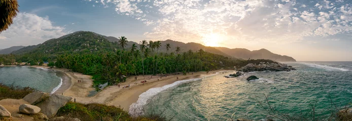 Fototapeten Schöner karibischer Strand mit Palmen und Sonnenuntergang im Tayrona-Nationalpark in der Nähe von Santa Marta in Nordkolumbien © iferol