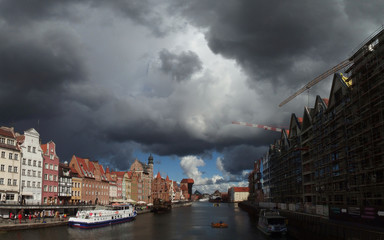 Polska, Gdańsk, Długie Pobrzeże - groźne, czarne chmury nad miastem, podświetlone słońcem © Iwona