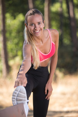 young fitness woman runner stretching legs before run