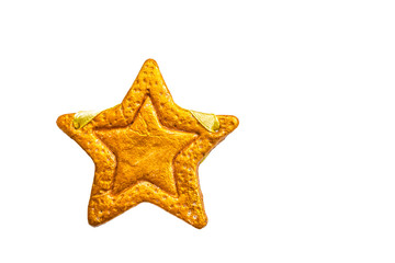 Decorative golden star handmade from dough isolated on a white background. View of the top.