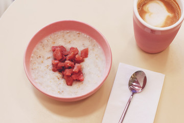 Breakfast oatmeal porrige with canned apples and cappuccino, minimalism
