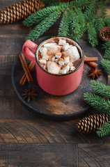 Obraz na płótnie Canvas Hot chocolate with marshmallows on rustic wooden background. Christmas concept decorated with Fir branches and Cones.