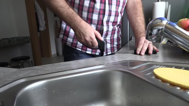 The man is sharpening a kitchen knife