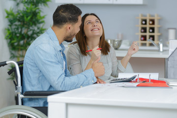 Fototapeta premium young man in wheelchair talking with his happy girlfriend