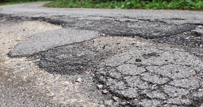Heavy damaged asphalt road.
