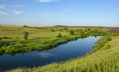 Beautiful view of river curve,green and green fields illuminated by the warm light of rising sun.